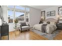 Bright bedroom featuring large windows, a decorative accent wall, and hardwood floors at 30 Garfield St # G, Denver, CO 80206