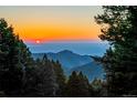 Scenic mountain view at sunset showcases breathtaking natural beauty, promising a tranquil and picturesque living experience at 13416 Kuehster Rd, Littleton, CO 80127