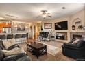 Open-concept living room with breakfast bar, fireplace, media center and comfortable sofas at 10818 Cimarron St # 1202, Firestone, CO 80504