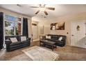 Inviting living room featuring large windows, neutral walls, modern ceiling fan, and comfortable furnishings at 10818 Cimarron St # 1202, Firestone, CO 80504