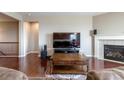 Comfortable living room featuring a fireplace, media center, and hardwood floors at 6265 S Ider Way, Aurora, CO 80016