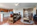 Open-concept living area featuring hardwood floors, a cozy seating area, and an adjacent kitchen at 6265 S Ider Way, Aurora, CO 80016
