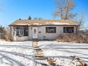 Tan one-story house with snow covered yard, daytime photo at 5191 S Pennsylvania St, Littleton, CO 80121