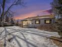 Tan one-story house with snow covered yard, evening photo at 5191 S Pennsylvania St, Littleton, CO 80121