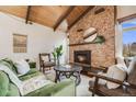 Cozy living room featuring a stone fireplace, wood-beamed ceiling, and stylish furnishings at 2837 Reed St, Wheat Ridge, CO 80033