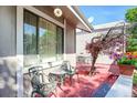 Cozy red-toned porch featuring metal chairs and table with a view of outdoor plants at 3853 S Genoa Ct # D, Aurora, CO 80013