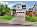 Charming gray two-story home with a manicured lawn and a two-car garage at 16048 Elizabeth St, Thornton, CO 80602