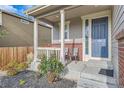 Inviting front porch with chairs, decorative columns and brick accents at 16048 Elizabeth St, Thornton, CO 80602