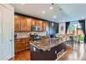 Stylish kitchen featuring wood cabinets, granite countertops, stainless steel appliances, and breakfast nook at 16048 Elizabeth St, Thornton, CO 80602