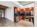A kitchen with dark wood cabinets, stainless steel appliances, and black tile backsplash at 1700 Bassett St # 802, Denver, CO 80202