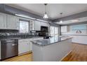 Bright kitchen boasts an island, modern appliances, white cabinets, and stylish backsplash at 1641 Orchard Dr, Denver, CO 80221
