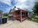 Angle shot of single-story home, featuring a covered red porch and vinyl siding at 888 Wolff St, Denver, CO 80204
