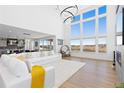 Bright living room with soaring ceilings, large windows, modern lighting and a decorative fireplace at 7517 Copper Sky Ct, Castle Pines, CO 80108