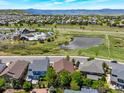 Overhead view of the community showcasing homes, green spaces, a pond, and a community pool at 2872 Dreamcatcher Loop, Castle Rock, CO 80109