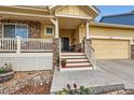 Charming covered front porch with stone pillars and a welcoming entrance to the home at 2872 Dreamcatcher Loop, Castle Rock, CO 80109