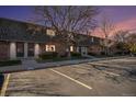 Brick townhomes feature well-manicured lawns and parking spaces during a dusk sky at 15107 E Wesley Ave, Aurora, CO 80014