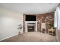 Cozy living room with brick fireplace, carpet and white trim at 15107 E Wesley Ave, Aurora, CO 80014