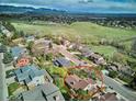 Expansive aerial view highlighting the property's location amidst green spaces and distant mountain views at 14072 W Alaska Dr, Lakewood, CO 80228