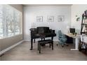 Bright living space featuring a grand piano, modern desk area, and large window with natural light at 1928 W 67Th Pl, Denver, CO 80221