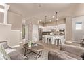 Open-concept living space featuring a kitchen with bar seating and a comfortable seating area at 1928 W 67Th Pl, Denver, CO 80221