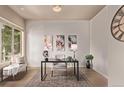 Office with bench seating by the window, a dark-wood desk and decorative wall art at 1928 W 67Th Pl, Denver, CO 80221