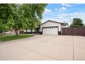 Exterior view highlighting ample parking with a wide driveway and attached two-car garage at 8595 S Yarrow St, Littleton, CO 80128
