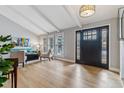 Bright living room featuring hardwood floors, vaulted ceilings, and a large front door with sidelights at 7484 E Mercer Pl, Denver, CO 80237