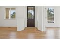 Open concept entryway featuring light hardwood flooring, white walls, and an abundance of natural light at 5035 Vermillion Dr, Castle Rock, CO 80108