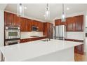 Modern kitchen with stainless steel appliances, dark wood cabinetry, a center island, and quartz countertops at 5035 Vermillion Dr, Castle Rock, CO 80108