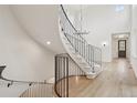 Elegant curved staircase with wrought iron railing, hardwood floors, and abundant natural light from high windows at 5035 Vermillion Dr, Castle Rock, CO 80108