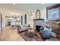 Cozy living room featuring a decorative brick fireplace, light wood floors, and modern furnishings at 2436 W 34Th Ave, Denver, CO 80211