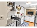 Well-appointed kitchen features modern appliances, white cabinetry, and a stylish range hood for a sleek, contemporary look at 11224 W 28Th Pl, Lakewood, CO 80215