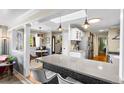 Bright, open kitchen with pendant lighting, island seating, quartz countertops, and stainless-steel appliances at 11224 W 28Th Pl, Lakewood, CO 80215