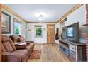 Cozy living room featuring hardwood floors, natural wood trim, and a rustic entertainment center at 4716 Broadway, Denver, CO 80216