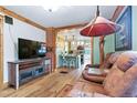 Open-concept design showcasing the living room flowing into the kitchen with hardwood floors and brick accents at 4716 Broadway, Denver, CO 80216