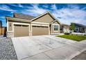 Attractive single-story home boasts a two car garage, and a concrete driveway with a nice lawn at 56459 E 23Rd Pl, Strasburg, CO 80136