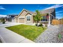 Charming home exterior featuring a well-maintained lawn, inviting porch, and an attached two-car garage at 56459 E 23Rd Pl, Strasburg, CO 80136