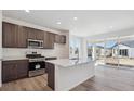 Kitchen with stainless appliances, quartz counters, large island and sliding doors to patio at 1311 Rock Cliff Ave, Erie, CO 80516
