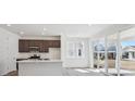 Bright kitchen features a quartz island, stainless appliances, and sliding glass doors to the backyard at 1311 Rock Cliff Ave, Erie, CO 80516