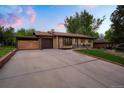 Long driveway view of a well maintained home, manicured lawn, and updated siding at 2840 S Yates St, Denver, CO 80236