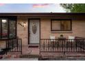 Close-up of the front porch featuring bistro seating and a decorative front door with sidelights at 2840 S Yates St, Denver, CO 80236
