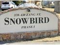 The Snowbird Phase I community sign featuring stone accents and manicured grounds at 390 Zang St # 5-102, Lakewood, CO 80228