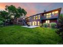 A spacious backyard featuring a well-maintained lawn, patio with fire pit, and a second-story deck at 8696 W Iliff Ave, Lakewood, CO 80227