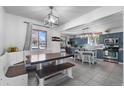 A dining room boasts an adjacent kitchen with ample natural light and cozy bench seating at 2381 Newark St, Aurora, CO 80010