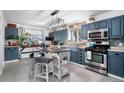 Bright kitchen featuring blue cabinets, stainless steel appliances, and a large kitchen island at 2381 Newark St, Aurora, CO 80010