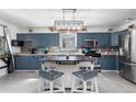 Modern kitchen with blue cabinets, stainless steel appliances, and a rustic kitchen island at 2381 Newark St, Aurora, CO 80010