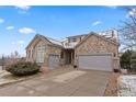 Attractive exterior features stone accents, a three-car garage, and solar panels creating an inviting curb appeal at 1752 Peninsula Cir, Castle Rock, CO 80104