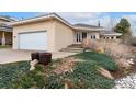 Tan exterior and well-manicured front garden with a two-car garage and a welcoming entryway at 1904 S Union Pl, Lakewood, CO 80228