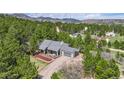 Aerial view of a gray home nestled amongst trees and nature at 3640 Summertime Ct, Monument, CO 80132
