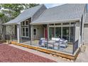 Inviting covered porch features comfortable seating, a red door, and stylish lighting at 3640 Summertime Ct, Monument, CO 80132